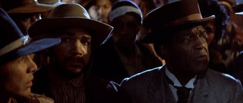 Movie still from “Posse” (1993), directed by Mario Van Peebles – A group of men wearing hats in the dark; Close Up shot, Low angle