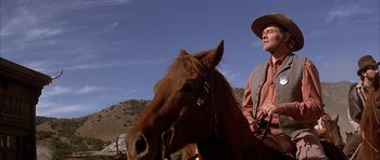Movie still from “Posse” (1993), directed by Mario Van Peebles – A man in a cowboy hat is riding a horse; Medium shot, Low angle