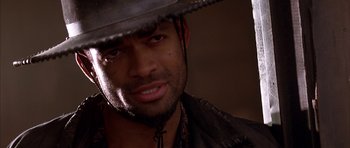 Movie still from “Posse” (1993), directed by Mario Van Peebles – A person wearing a cowboy hat; Close Up shot, Over the shoulder angle