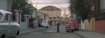 Movie still from “Post Mortem” (2010), directed by Pablo Larraín – A man standing on the side of the street; Extreme Wide shot, Low angle