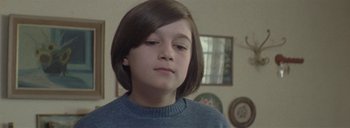 Movie still from “Post Mortem” (2010), directed by Pablo Larraín – A young girl is looking at the camera; Close Up shot, High angle