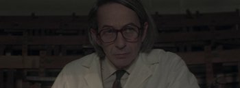 Movie still from “Post Mortem” (2010), directed by Pablo Larraín – A man in a white lab coat and glasses; Close Up shot, Low angle