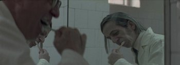 Movie still from “Post Mortem” (2010), directed by Pablo Larraín – A woman brushing her teeth in a bathroom mirror; Close Up shot, Over the shoulder angle
