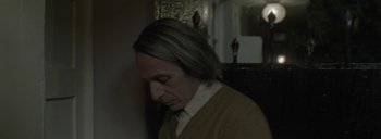 Movie still from “Post Mortem” (2010), directed by Pablo Larraín – A man with long gray hair is looking down; Close Up shot, Over the shoulder angle