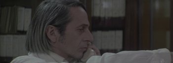 Movie still from “Post Mortem” (2010), directed by Pablo Larraín – An older man talking on a phone while wearing a white shirt; Close Up shot, Over the shoulder angle