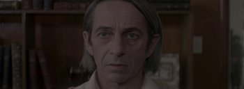 Movie still from “Post Mortem” (2010), directed by Pablo Larraín – A person with long hair; Close Up shot, Over the shoulder angle