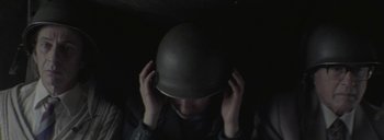 Movie still from “Post Mortem” (2010), directed by Pablo Larraín – A man wearing a military helmet in the dark; Close Up shot, Overhead angle