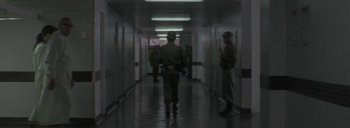 Movie still from “Post Mortem” (2010), directed by Pablo Larraín – A group of soldiers walking down a hall way; Wide shot, Low angle