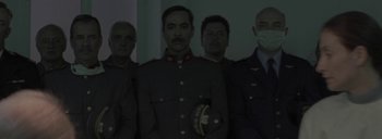 Movie still from “Post Mortem” (2010), directed by Pablo Larraín – A group of men standing next to each other in uniforms; Medium shot, Low angle