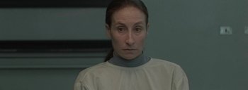 Movie still from “Post Mortem” (2010), directed by Pablo Larraín – A woman in a white shirt is looking at the camera; Close Up shot, Low angle