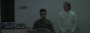 Movie still from “Post Mortem” (2010), directed by Pablo Larraín – A man sitting in front of an old typewriter; Medium shot, Low angle