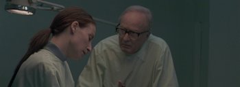 Movie still from “Post Mortem” (2010), directed by Pablo Larraín – An older man and a young woman are talking to each other; Close Up shot, Over the shoulder angle