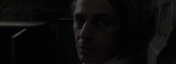Movie still from “Post Mortem” (2010), directed by Pablo Larraín – A person's face in the dark; Close Up shot, Over the shoulder angle
