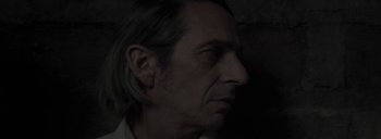 Movie still from “Post Mortem” (2010), directed by Pablo Larraín – A person's face in the dark; Close Up shot, Low angle