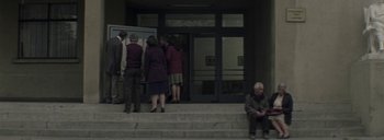 Movie still from “Post Mortem” (2010), directed by Pablo Larraín – A group of people standing on the steps of a building; Wide shot, Low angle