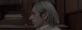 Movie still from “Post Mortem” (2010), directed by Pablo Larraín – A person with long white hair; Close Up shot, Low angle