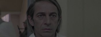 Movie still from “Post Mortem” (2010), directed by Pablo Larraín – A person wearing a white shirt; Close Up shot, Over the shoulder angle