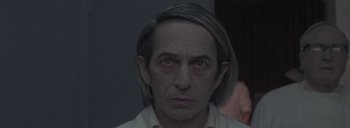 Movie still from “Post Mortem” (2010), directed by Pablo Larraín – A person with long grey hair; Close Up shot, High angle
