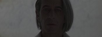 Movie still from “Post Mortem” (2010), directed by Pablo Larraín – A person's face in a dark room; Close Up shot, Low angle