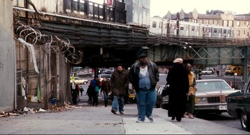 Movie still from “Precious” (2009), directed by Lee Daniels – A group of people walking down a sidewalk; Wide shot, Over the shoulder angle