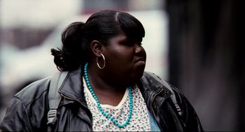 Movie still from “Precious” (2009), directed by Lee Daniels – A black woman with a blue necklace and a black leather jacket; Close Up shot, Over the shoulder angle