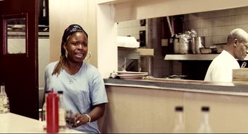Movie still from “Precious” (2009), directed by Lee Daniels – A woman sitting at a table in a kitchen; Medium shot, Over the shoulder angle