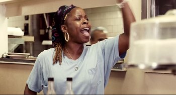 Movie still from “Precious” (2009), directed by Lee Daniels – A woman in a white shirt is singing in a kitchen; Close Up shot, Low angle