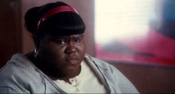 Movie still from “Precious” (2009), directed by Lee Daniels – A person sitting down wearing a headband; Close Up shot, High angle