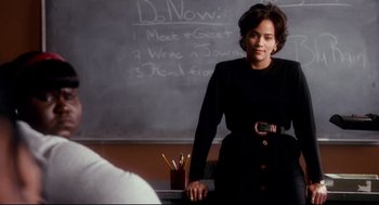 Movie still from “Precious” (2009), directed by Lee Daniels – A woman standing in front of a chalkboard; Medium shot, Over the shoulder angle