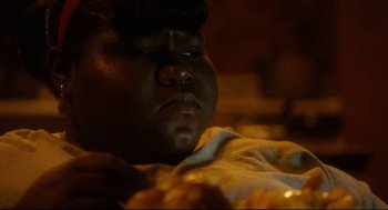 Movie still from “Precious” (2009), directed by Lee Daniels – A person's face in a dark room; Close Up shot, Over the shoulder angle