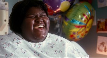Movie still from “Precious” (2009), directed by Lee Daniels – A person that is sitting in front of some balloons; Close Up shot, High angle