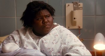 Movie still from “Precious” (2009), directed by Lee Daniels – A woman sitting in a hospital bed with her mouth open; Close Up shot, High angle