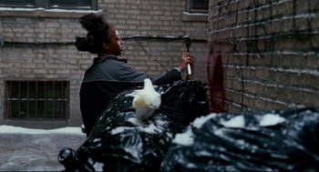 Movie still from “Precious” (2009), directed by Lee Daniels – A person with a brush in their hand and a brush in their mouth; Medium shot, Over the shoulder angle