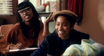 Movie still from “Precious” (2009), directed by Lee Daniels – Two people sitting at a table and one is wearing a hat; Medium shot, Over the shoulder angle