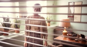 Movie still from “Precious” (2009), directed by Lee Daniels – A woman standing in a room behind blinds; Medium shot, Low angle
