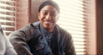 Movie still from “Precious” (2009), directed by Lee Daniels – A young man smiling for the camera wearing a black hat; Close Up shot, Over the shoulder angle