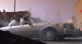 Movie still from “Predator 2” (1990), directed by Stephen Hopkins – A car that has been hit by a bullet; Wide shot, Low angle