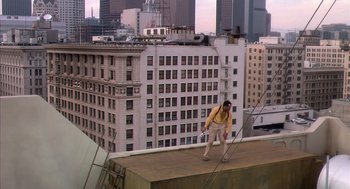 Movie still from “Predator 2” (1990), directed by Stephen Hopkins – A man standing on top of a building on top of a building; Extreme Wide shot, High angle