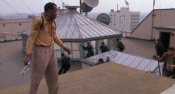 Movie still from “Predator 2” (1990), directed by Stephen Hopkins – A man standing on top of a building near a group of people; Wide shot, Low angle
