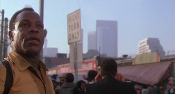 Movie still from “Predator 2” (1990), directed by Stephen Hopkins – A group of people standing next to each other on the street; Close Up shot, Low angle