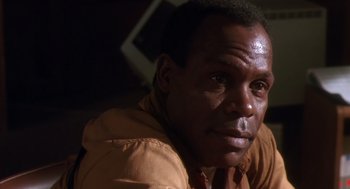 Movie still from “Predator 2” (1990), directed by Stephen Hopkins – A person wearing a brown shirt; Close Up shot, Low angle
