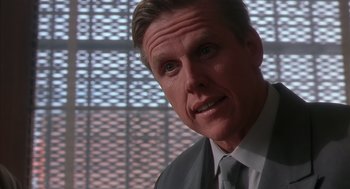 Movie still from “Predator 2” (1990), directed by Stephen Hopkins – A person wearing a suit and tie; Close Up shot, Low angle