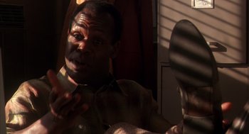 Movie still from “Predator 2” (1990), directed by Stephen Hopkins – A man is talking to someone in the mirror; Close Up shot, Low angle