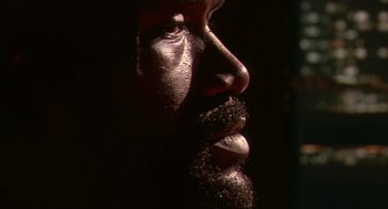 Movie still from “Predator 2” (1990), directed by Stephen Hopkins – A man's face in the dark; Extreme Close Up shot, Low angle