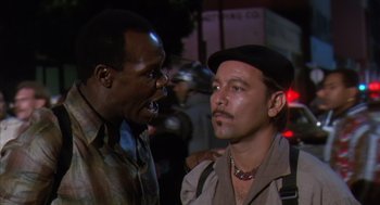 Movie still from “Predator 2” (1990), directed by Stephen Hopkins – Two men talking to each other on a city street; Close Up shot, Over the shoulder angle