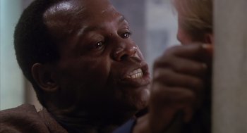 Movie still from “Predator 2” (1990), directed by Stephen Hopkins – A person with a hand on his face; Close Up shot, Over the shoulder angle