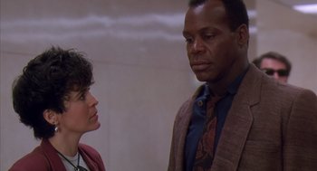 Movie still from “Predator 2” (1990), directed by Stephen Hopkins – A man and a woman standing next to each other; Close Up shot, Low angle