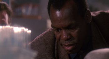 Movie still from “Predator 2” (1990), directed by Stephen Hopkins – A person sitting down looking down; Close Up shot, Low angle