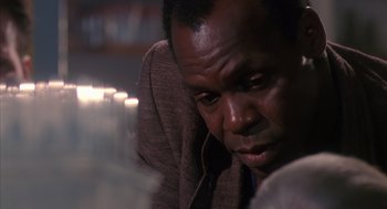 Movie still from “Predator 2” (1990), directed by Stephen Hopkins – A person sitting in a chair; Close Up shot, Over the shoulder angle