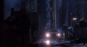 Movie still from “Predator 2” (1990), directed by Stephen Hopkins – A car driving down a street at night; Extreme Wide shot, Low angle